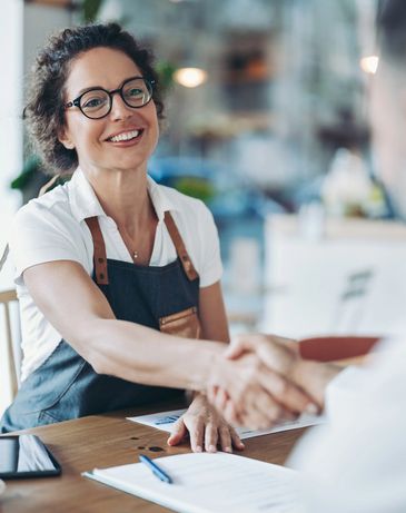 Couple sitting on the kitchen floor sharing a joyful high-five moment.