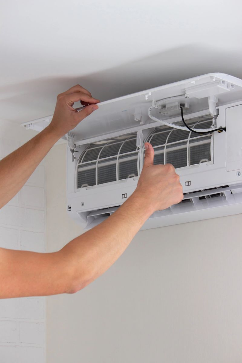 Maintenance Complete. Technician Installing Clean Air Filter in Air Conditioner.