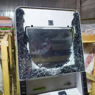 A broken ATM with shattered glass.