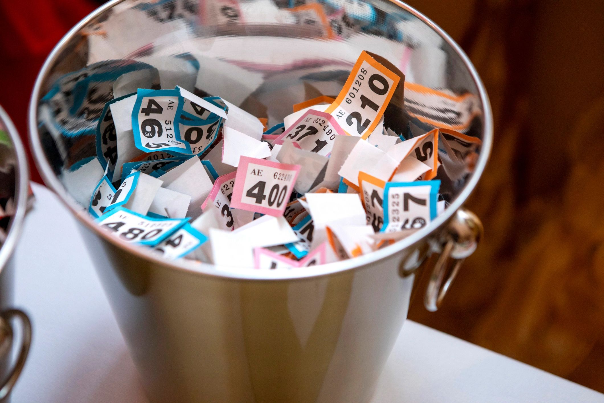 Colorful raffle tickets in a shiny silver trophy cup.