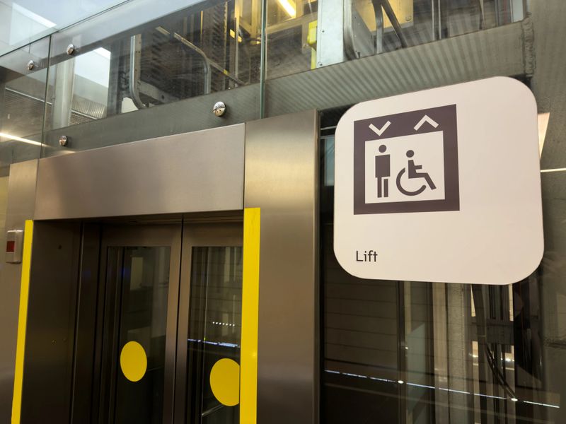 Modern stainless steel elevator with clear accessibility symbol for people with disabilities, highlighting inclusive urban infrastructure in public transport environments