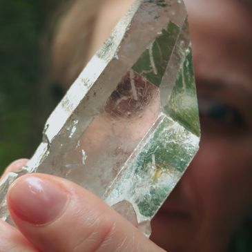 Person holding a large clear crystal up close to the camera.