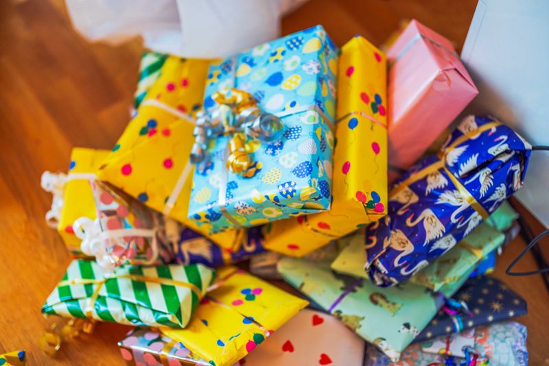 Close up view of children gifts wrapped in colorful paper with ribbons lying on wooden floor. Sweden.