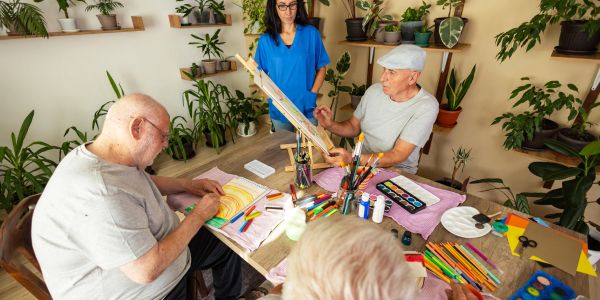 Seniors painting in an art class with instructor.