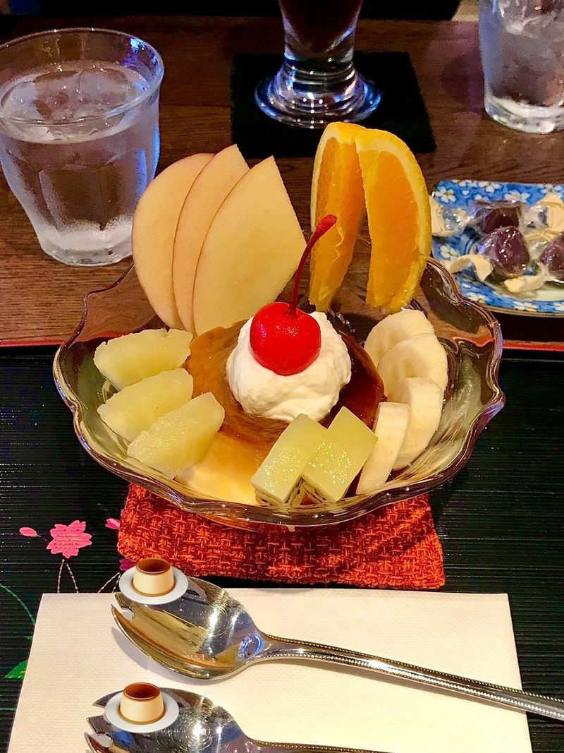 Creamy pudding à la mode topped with fresh fruits and a scoop of ice cream, offering a perfect harmony of smooth, sweet, and refreshing flavors in every elegant and delightful spoonful.