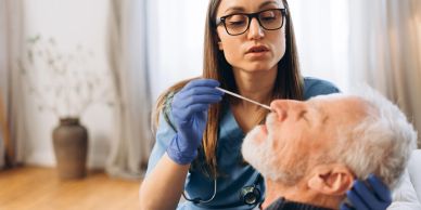 Nurse performing a nasal swab test on an elderly man.