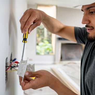 Man installing or repairing an electrical outlet.