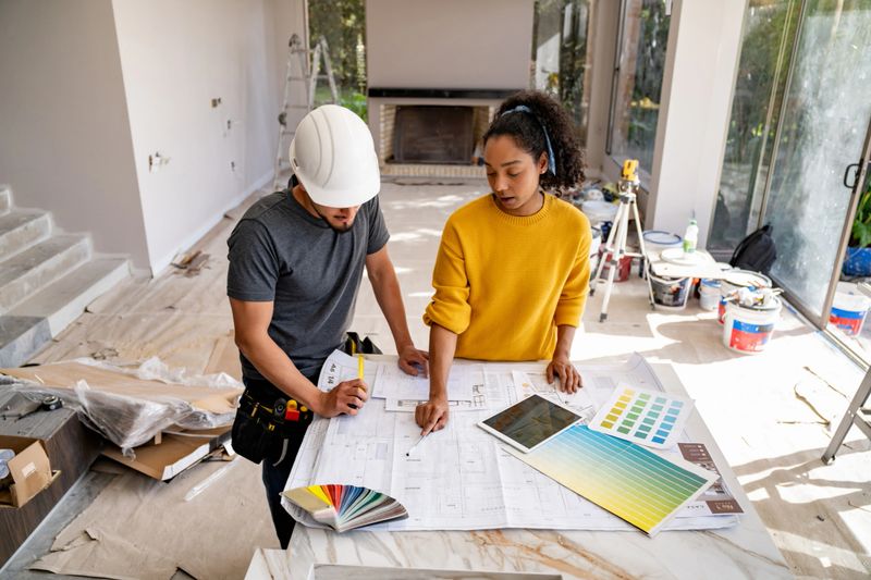 Latin American architect talking to a building contractor while remodeling a house