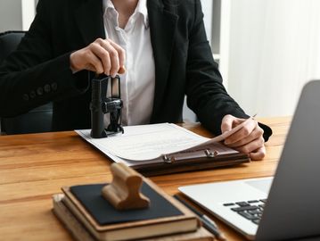 Person stamping a document in an office setting.