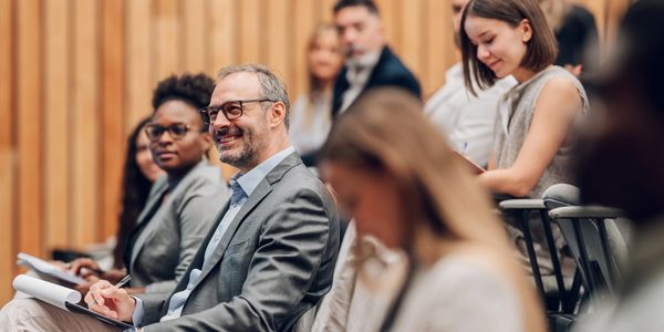 Professionals attentively listening during a conference or seminar.
