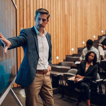 Man presenting to an audience in a lecture hall.