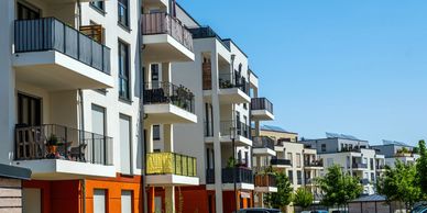 Modern apartment buildings under a clear blue sky.