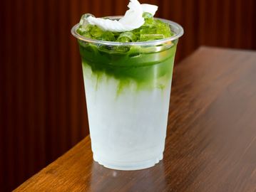 Iced matcha latte with whipped cream.
