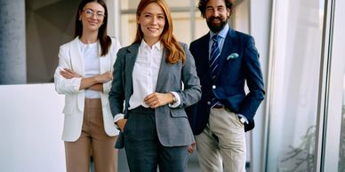 Three confident business professionals posing indoors.