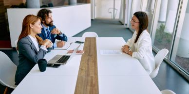 Three professionals in a job interview setting.