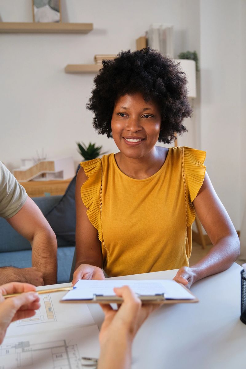 Young black woman receiving a contract to sign from an estate agent