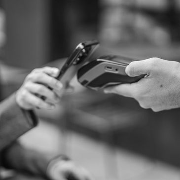A person making a contactless payment with a smartphone.