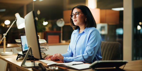 Woman working on computer in cozy office.