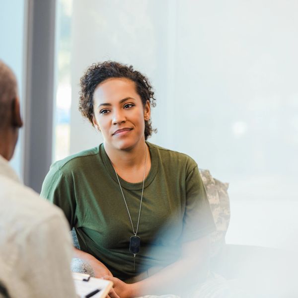 A woman listens attentively to a man during a conversation indoors.