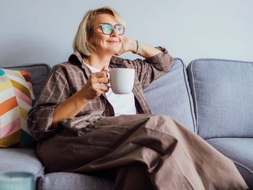 Woman relaxing on couch with coffee.