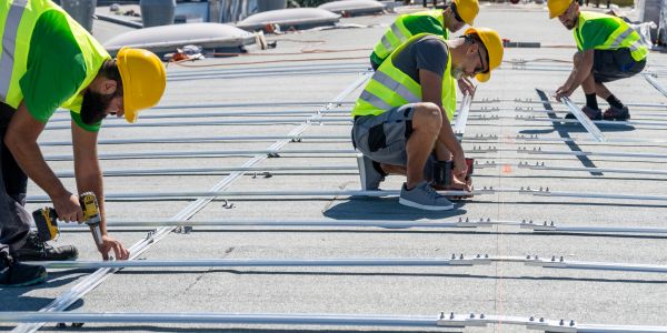 Electricians wiring a fixture, ensuring safety and precision.