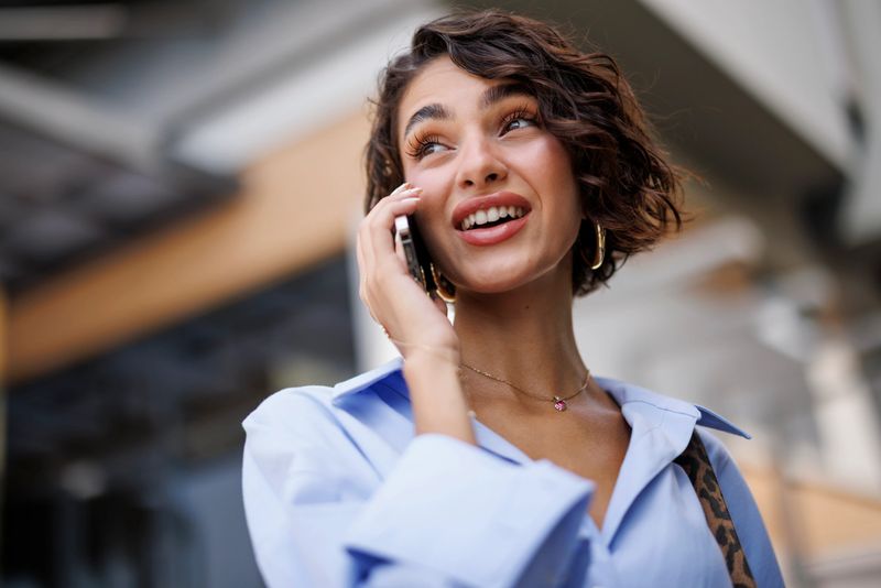 Portrait of successful businesswoman talking on phone outside the office