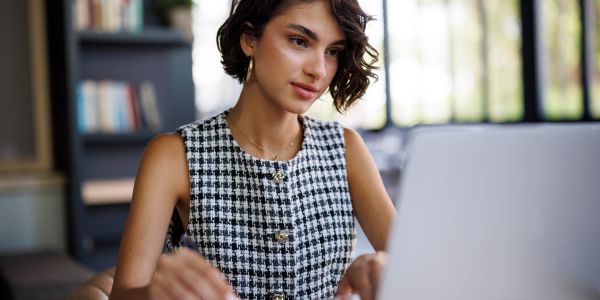 Young woman focused on her laptop in a cozy office.