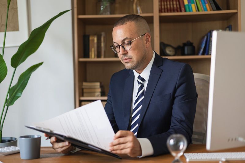 Businessman concentrating on legal documents, working with paperwork in a professional office