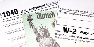 U.S. tax forms 1040 and W-2 with a partial view of a Social Security card.