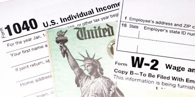 U.S. tax forms with a dollar bill showing the Statue of Liberty.