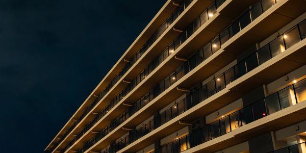 Exterior view of a modern apartment building at night.