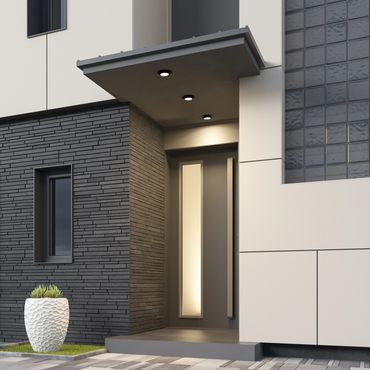 Modern house entrance with sleek door, textured wall, and decorative planter.