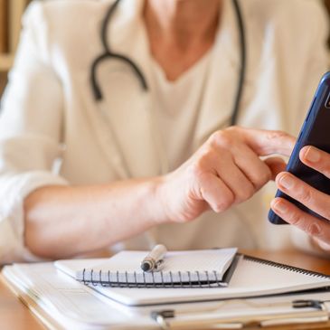Healthcare professional using a smartphone for a remote consultation.