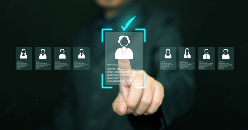 Human resources manager analyzing applicant profiles on virtual screen. Modern concept of digital recruitment, AI candidate selection, HR analytics, and smart hiring technology in business.