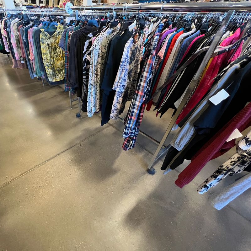 Thrift store clothes on a rack.