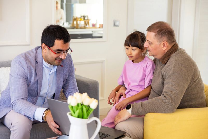 Financial advisor having a meeting with a multiracial family in their home
