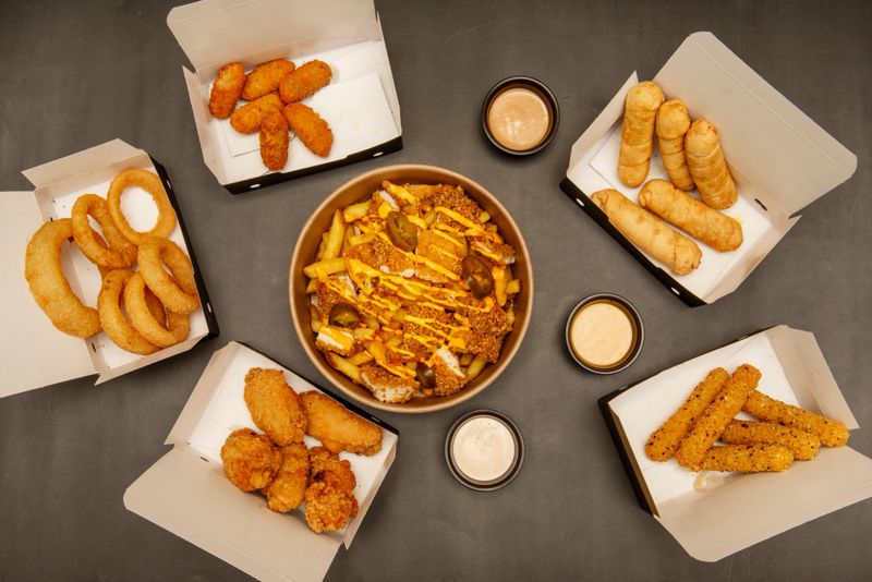 Perfectly golden fried chicken nuggets, with a crispy exterior and juicy interior, served with barbecue sauce and mustard
