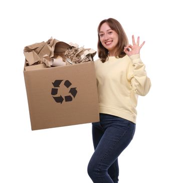 Woman holding a recycling box filled with paper waste.
