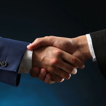 Two people shaking hands in formal attire.