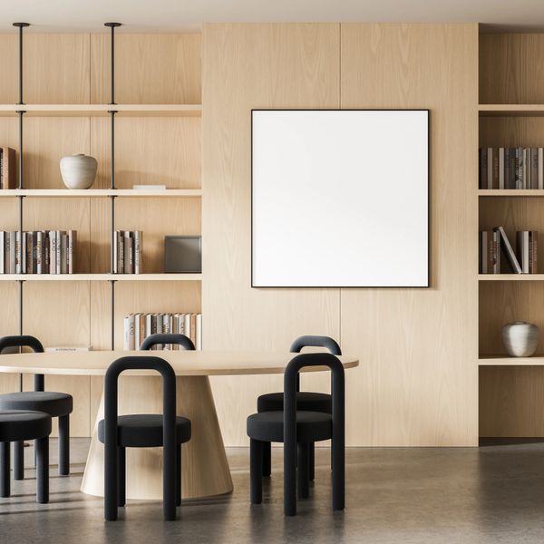 Minimalist dining area with black chairs and light wood shelving.