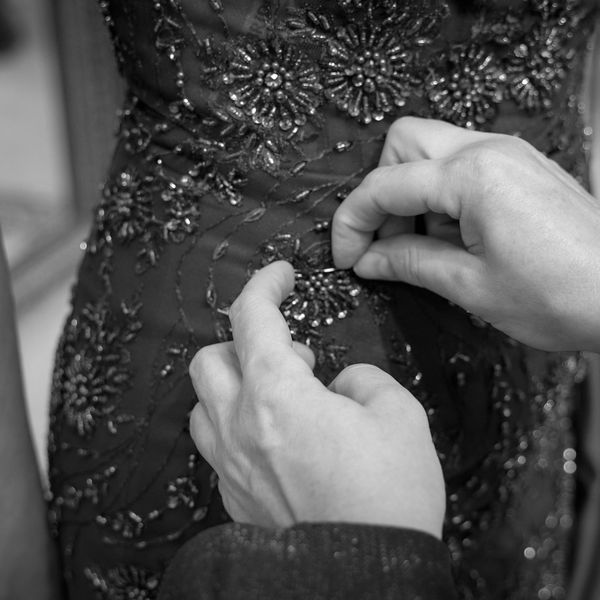 Tailor adjusting a blue sequin evening dress for alterations