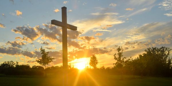 Cross silhouetted against a sunset sky.