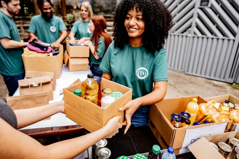 Volunteer woman passing donation box outdoors