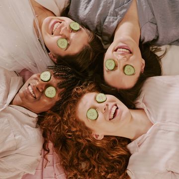 Four friends relaxing with cucumber slices on their eyes.