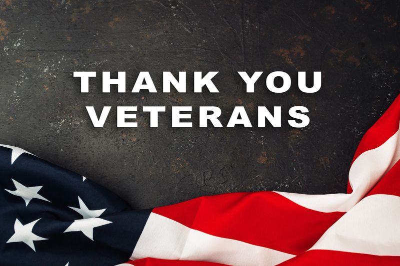 Flag with the words Thank You Veterans written below it. The flag is red and white with stars