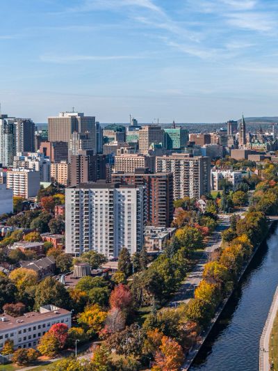 City skyline with fall foliage near a river.