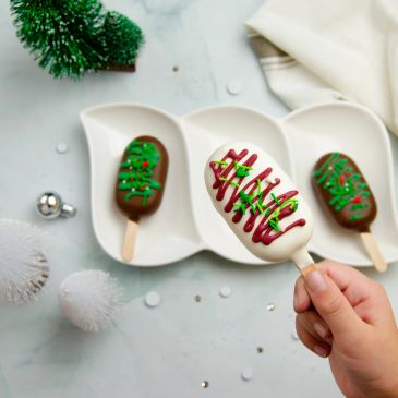 Festive decorated chocolate ice cream bars on a tray.
