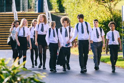 Group of students walking in school uniforms.