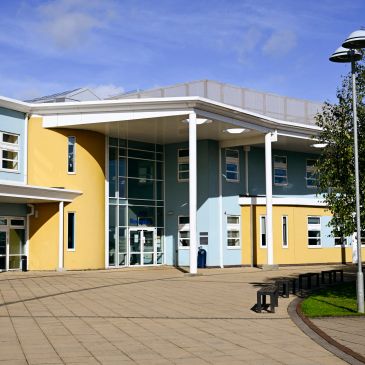 Modern school building with blue and yellow walls.