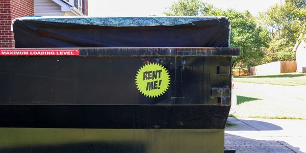 Dumpster with a 'Rent Me!' sign outdoors.